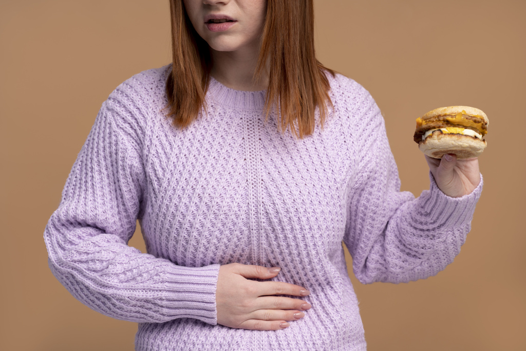tgbn9a_woman-with-eating-disorder-trying-eat-burger.jpg